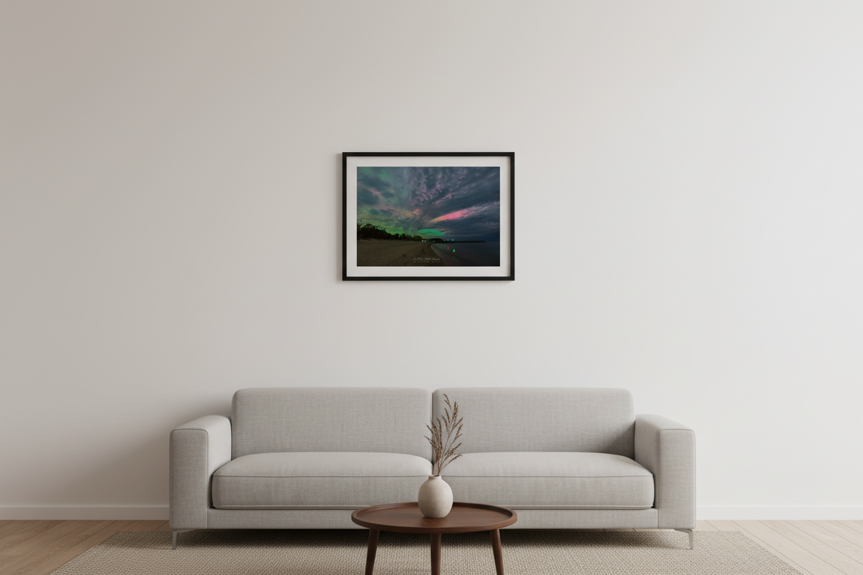 Small fine art landscape print of vivid green and pink aurora borealis illuminating dramatic clouds over Fishtown Leland Michigan beach May 10 2024 displayed in modern living room