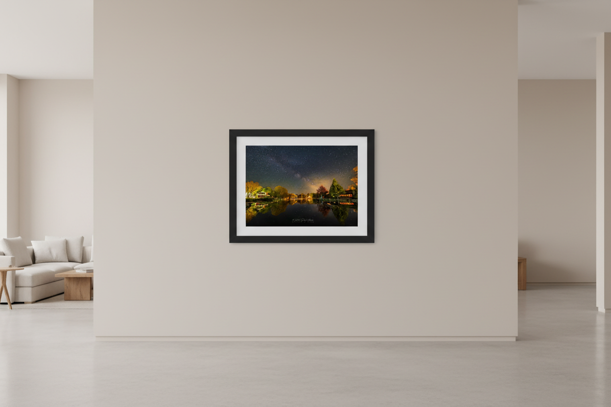 Small fine art landscape print of the Milky Way rising over the Leland River with warm golden cottage lights reflecting on the glassy water and autumn trees on both sides May 15 2023 displayed in modern living room