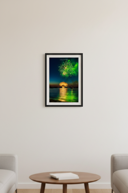 Small fine art portrait print of Traverse City Cherry Festival 2024 finale fireworks featuring electric green and gold bursts reflecting over Grand Traverse Bay from Clinch Park Beach displayed in modern living room