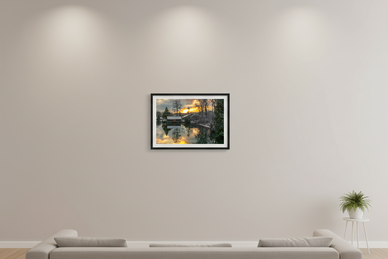 Small fine art landscape print of snowy Christmas boathouse scene with fiery golden sunrise reflecting in still water Leland Michigan December 2022 displayed in modern living room