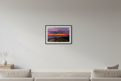 Small fine art print of peaceful purple magenta sunrise over Sleeping Bear Bay from elevated sand dune overlook at Sleeping Bear Point with dune grass foreground and blazing orange horizon band displayed in modern living room