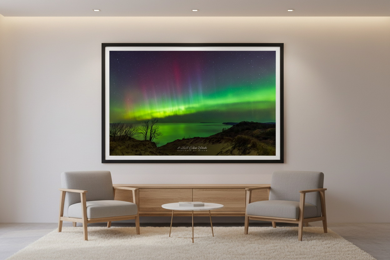 Large fine art landscape print of vivid lime green yellow and crimson red aurora borealis over Lake Michigan viewed from Empire Bluffs sandy dunes with silhouetted bare trees and dune grass in foreground Sleeping Bear Dunes Michigan March 24 2023 displayed in modern living room
