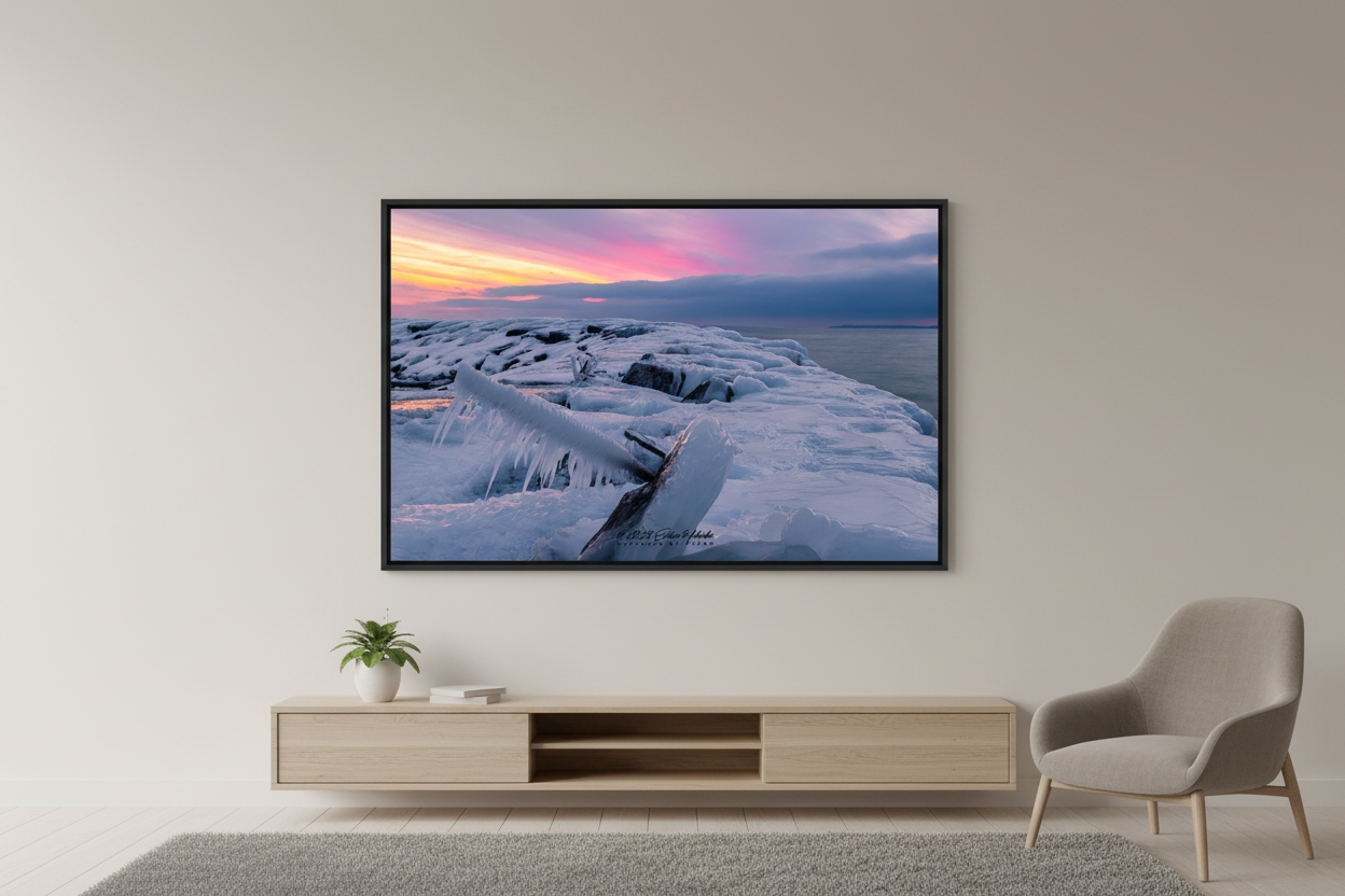 Large fine art landscape print of pink and magenta cotton candy afterglow sunset over ice-encrusted rocky breakwall with icicle foreground at Leland Michigan Lake Michigan February 18 2023 displayed in modern living room