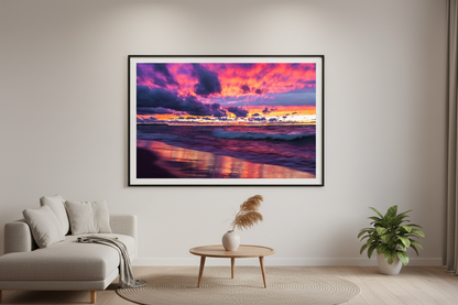Large fine art landscape print of vivid magenta violet gold sunset with dramatic storm clouds and glowing wave reflections on Lake Michigan beach Leland Michigan September 2021 displayed in modern living room