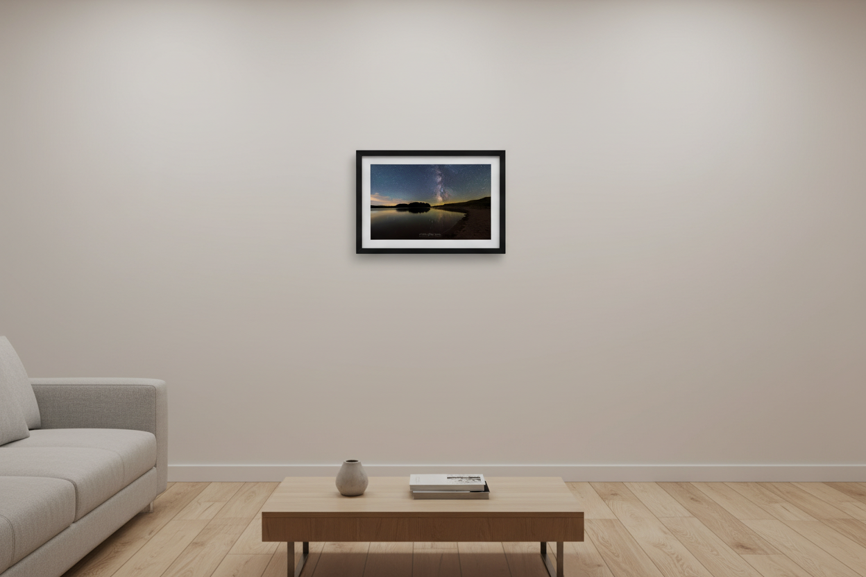 Small fine art print of Milky Way galaxy core rising over glassy North Bar Lake with island silhouette sandy dune shoreline and warm amber horizon glow Sleeping Bear Dunes displayed in modern living room