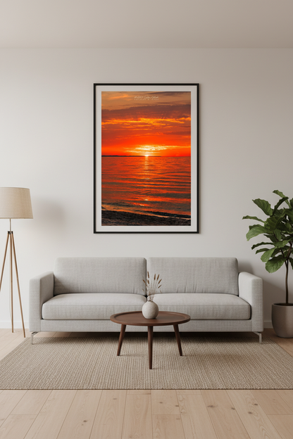 Large fine art portrait print of deep crimson orange sunset with golden reflection path across glassy calm Lake Michigan water Leland Michigan September 2024 displayed in modern living room