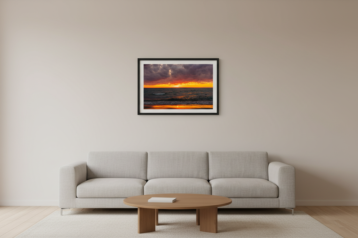 Small fine art landscape print of a dramatic fiery orange and crimson sunset afterglow with storm clouds over Lake Michigan from Port Oneida Michigan April 27 2024 displayed in modern living room