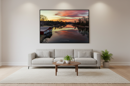 Large fine art landscape print of reflective fiery sunrise over Lake Leelanau Narrows with red boathouse Leelanau County Michigan November 2023 displayed in modern living room
