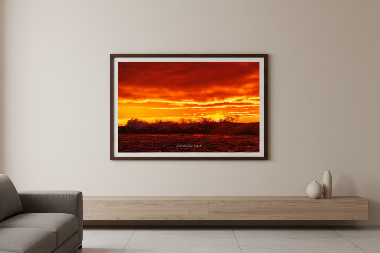 Large fine art landscape print of silhouetted crashing waves backlit by deep crimson and molten gold sunset sky at Leland Lake Michigan October 2023 displayed in modern living room