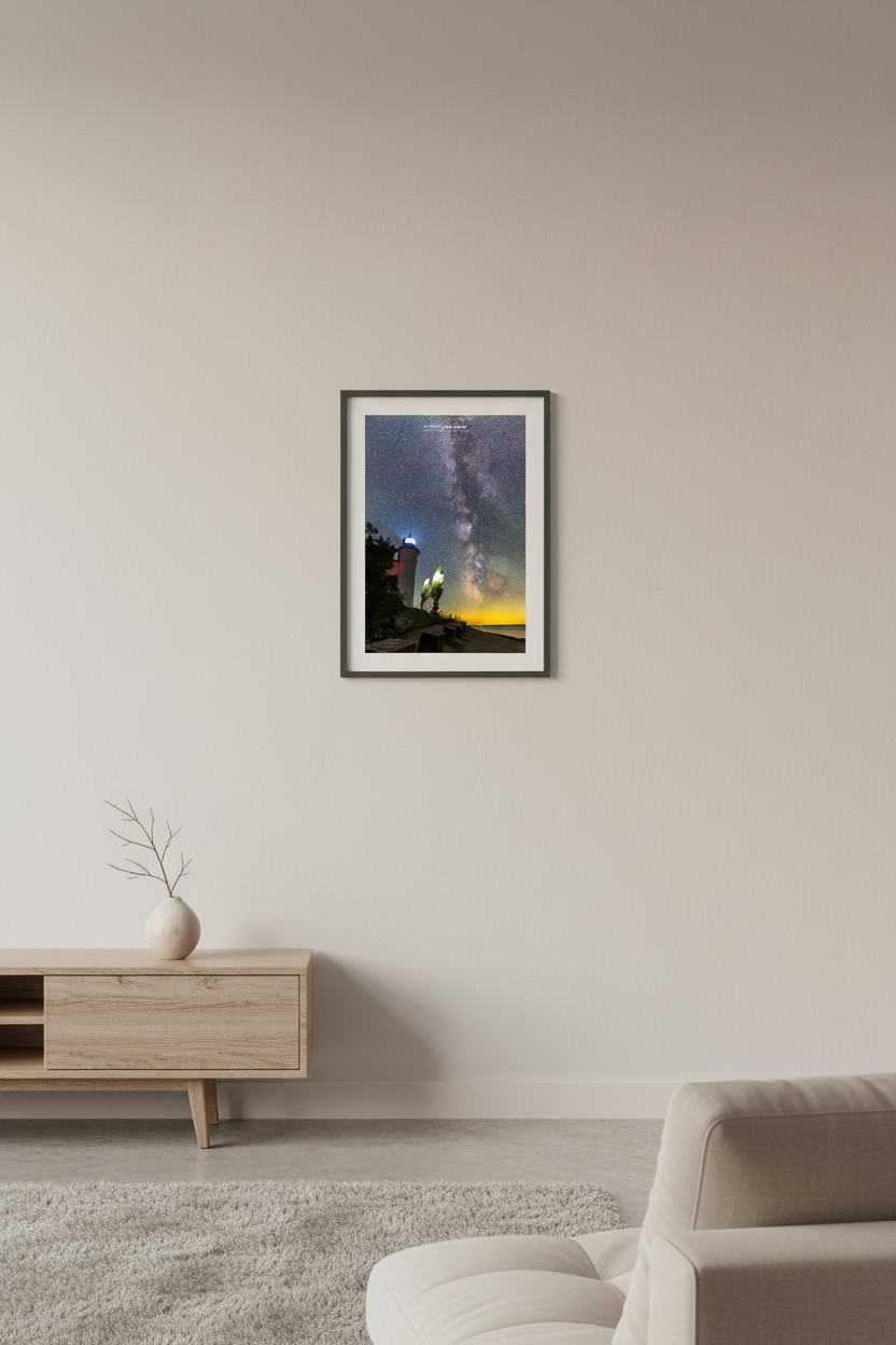 Small fine art portrait print of the Milky Way rising above the glowing Point Betsie Lighthouse on Lake Michigan Michigan August 5 2022 at 1:25am with golden horizon and star-filled sky displayed in modern living room