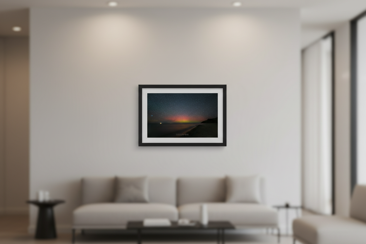 Small fine art print of full spectrum red orange yellow green aurora borealis curtain over Lake Michigan North Street Beach Leland Michigan bright point light on water curved sandy beach dark headland lower right Oct 5 2024 3:18am displayed in modern living room