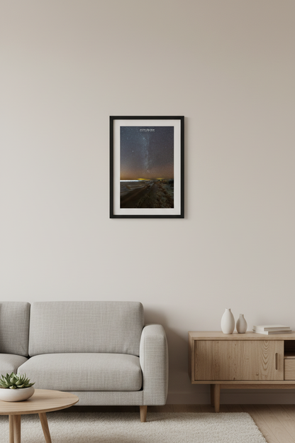 Small fine art portrait print of Milky Way rising over Lake Michigan beach and rocky breakwall with warm amber horizon glow at Leland Michigan February 11 2023 displayed in modern living room