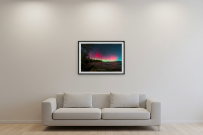 Small fine art print of split dual aurora structures with crimson left column and soft pink right glow over Lake Leelanau from Leland Michigan November 8 2024 8:33pm with meteor streak and water reflection displayed in modern living room