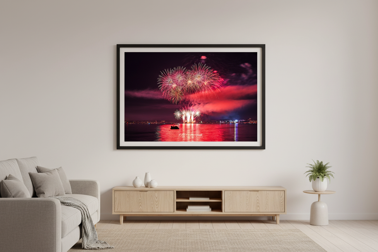 Large fine art landscape print of Traverse City 4th of July 2024 fireworks with crimson red sky, wide silver multi-burst canopy, and vivid red water reflection over Grand Traverse Bay displayed in modern living room