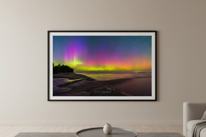 Large fine art landscape print of vivid full-spectrum Northern Lights aurora borealis with magenta purple and chartreuse green pillars over Shalda Creek beach at Sleeping Bear Dunes Lake Michigan Michigan September 2 2023 displayed in modern living room