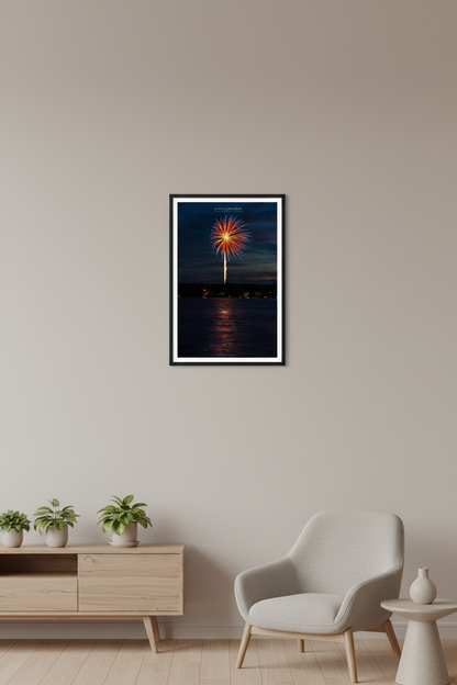 Small fine art portrait print of single red orange firework burst with golden launch trail and lake reflection over Lake Leelanau Leland Michigan July 3 2024 displayed in modern living room